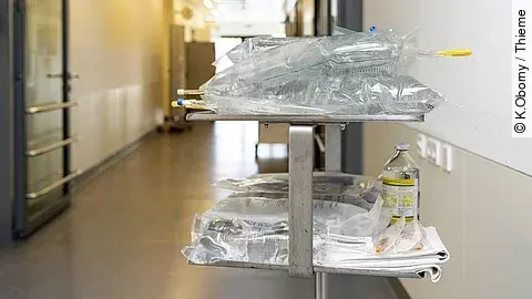 Auf einem Krankenhausflur steht ein Wagen mit mehreren Infusionen.
