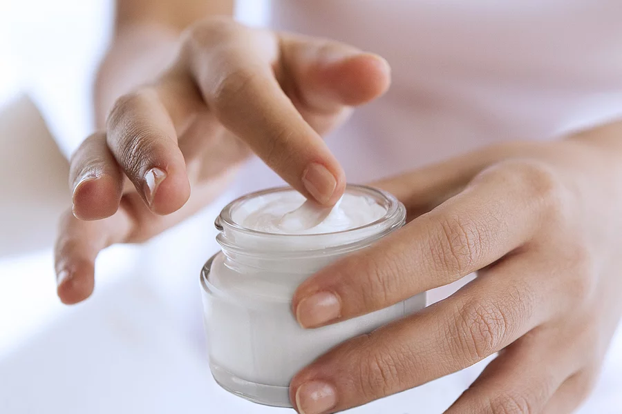 touching with softness Frauenhände entnehmen Creme aus einem Creme-Tiegel