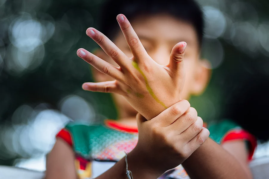 young boy with wrist pain Junge hält sich das Handgelenk