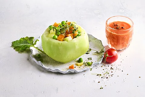 Frisches Gemüse als Gericht auf einem Teller angerichtet mit einem Glas Gemüsesaft