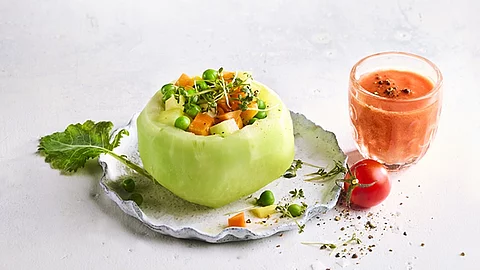 Frisches Gemüse als Gericht auf einem Teller angerichtet mit einem Glas Gemüsesaft