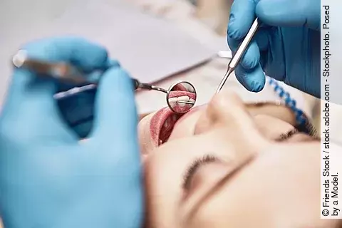 Frau auf Zahnarztstuhl wird behandelt