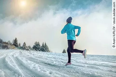 Frau joggt durch Schneelandschaft