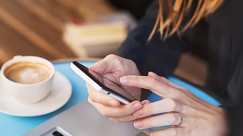 Bildausschnitt mit zwei Frauenhänden, die ein Smartphone halten.