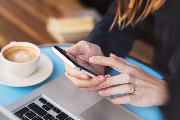 Bildausschnitt mit zwei Frauenhänden, die ein Smartphone halten.