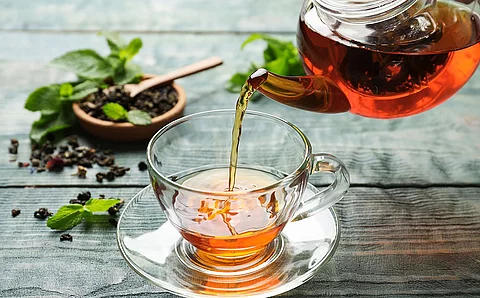 Tee wird aus gläserner Teekanne in gläserne Tasse geschenkt