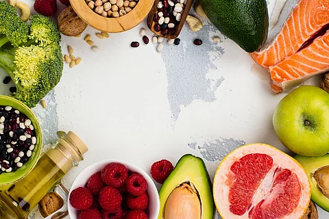 Gesunde Ernährung: Obst, Gemüse, Öl, Fisch auf weißem Untergrund