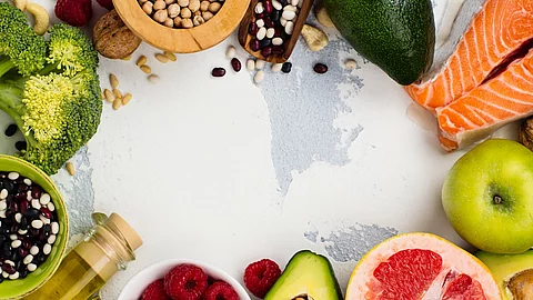 Healthy food or paleo diet concept Gesunde Ernährung: Obst, Gemüse, Öl, Fisch auf weißem Untergrund