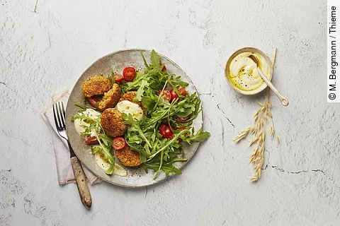 Teller mit Linsenbratlingen, Tomaten und Romanasalat