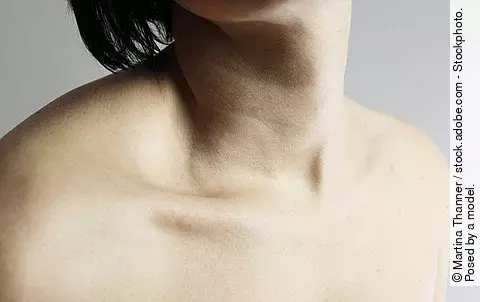 Frau mit schwarzen Haaren, ihr Hals und ihre Schultern sind unbedeckt.