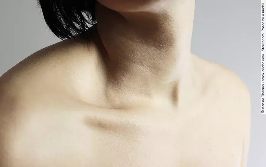 Frau mit schwarzen Haaren, ihr Hals und ihre Schultern sind unbedeckt.