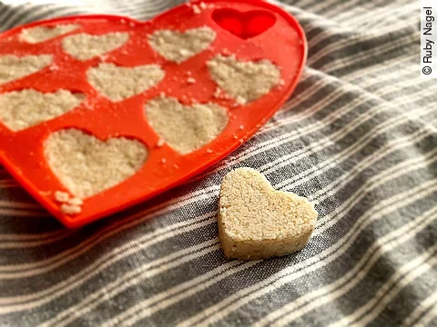 Badekugeln in Herzform in einer Form mit Herzen