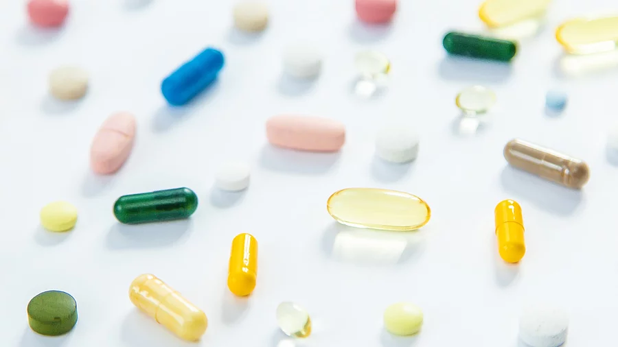 Bunte Pillen, Kapseln, Dragees und Tabletten auf hellem Hintergrund