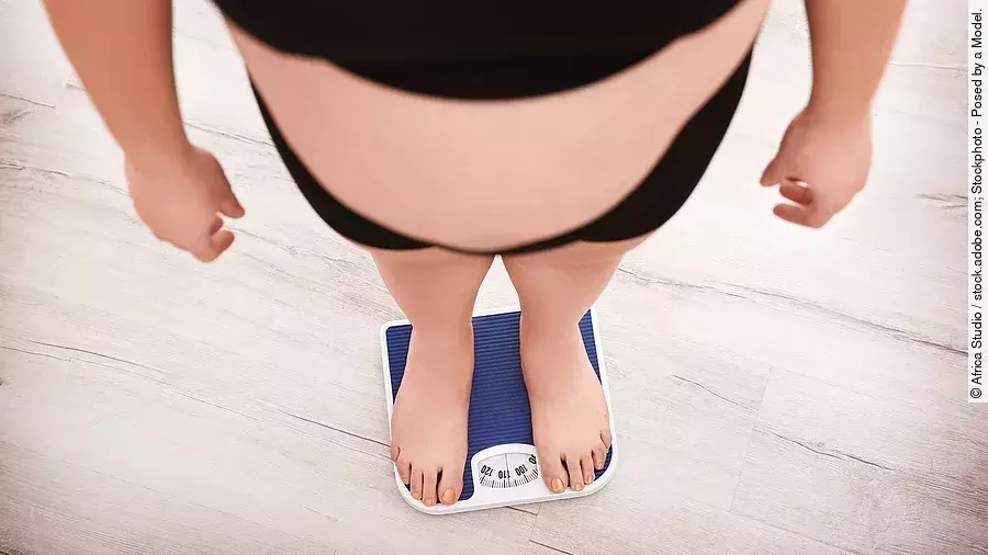 Übergewichtige Person auf einer Personenwaage