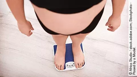 Übergewichtige Person auf einer Personenwaage