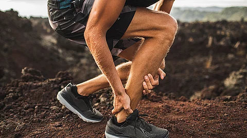 Läufer hält sich den Knöchel