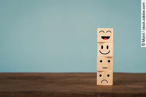 Verschiedene Gesichtsausdrücke auf Holzwürfeln.