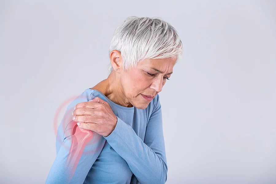 Senior woman with shoulder pain. Elderly woman is enduring awful Ältere Frau greift sich an die Schulter