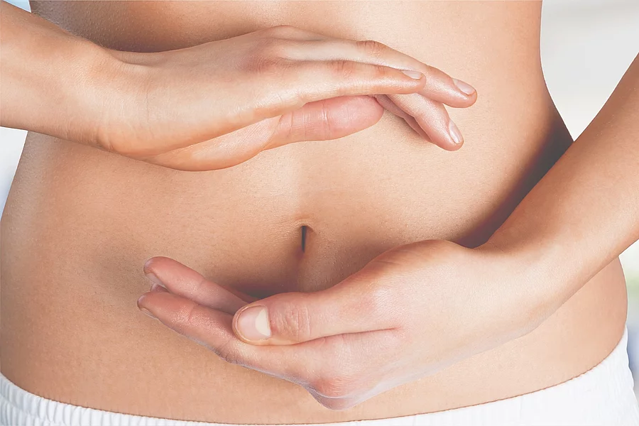 Abdomen balance beauty belly body bodycare button Frau hält ihre beiden Hänge im Kreis um ihren Bauchnabel.