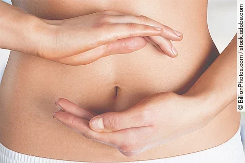 Frau hält ihre beiden Hänge im Kreis um ihren Bauchnabel.