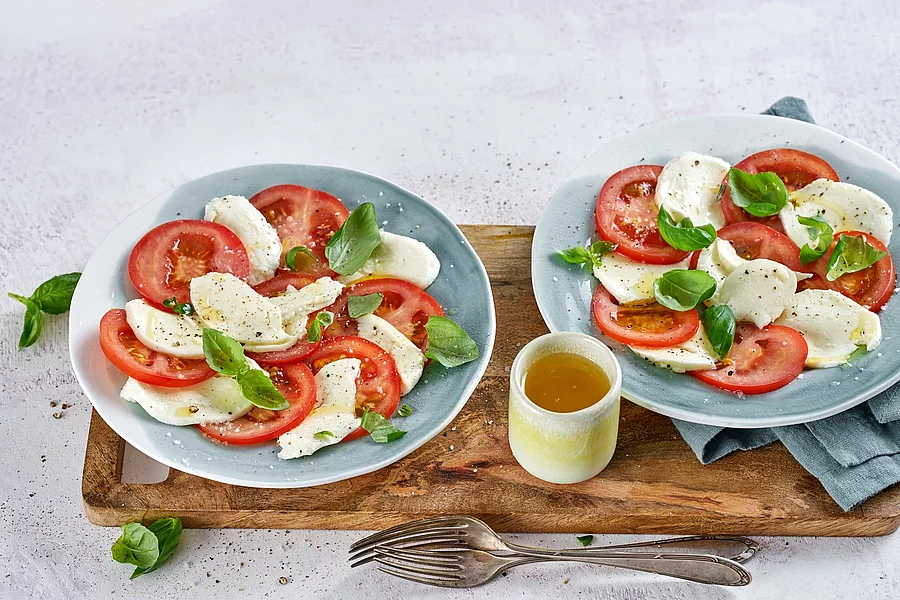 2 Teller mit Tomate, Mozzarella, Basilikum und Olivenöl