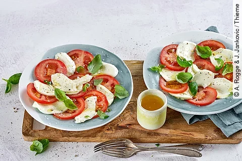 2 Teller mit Tomate, Mozzarella, Basilikum und Olivenöl