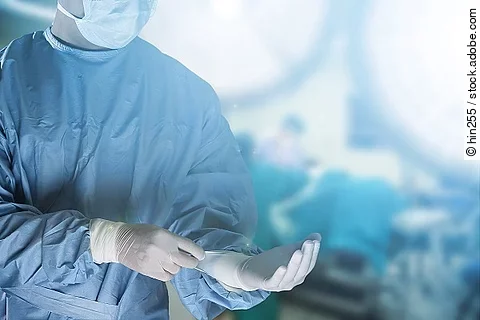 Operateurin zieht sich Handschuhe an