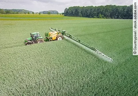 Mähdrescher mit Feldspritze auf dem Feld