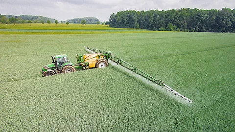 Mähdrescher mit Feldspritze auf dem Feld