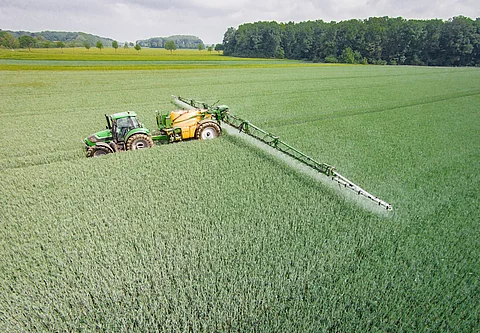 Mähdrescher mit Feldspritze auf dem Feld