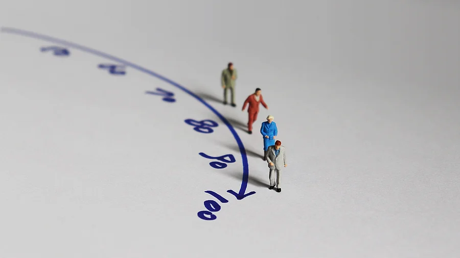 Miniaturmenschen neben einem Zeitstrahl bis 100 Jahre