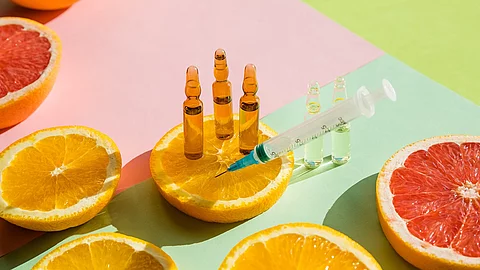 Orangen und Vitamin C Ampullen mit Spritze.