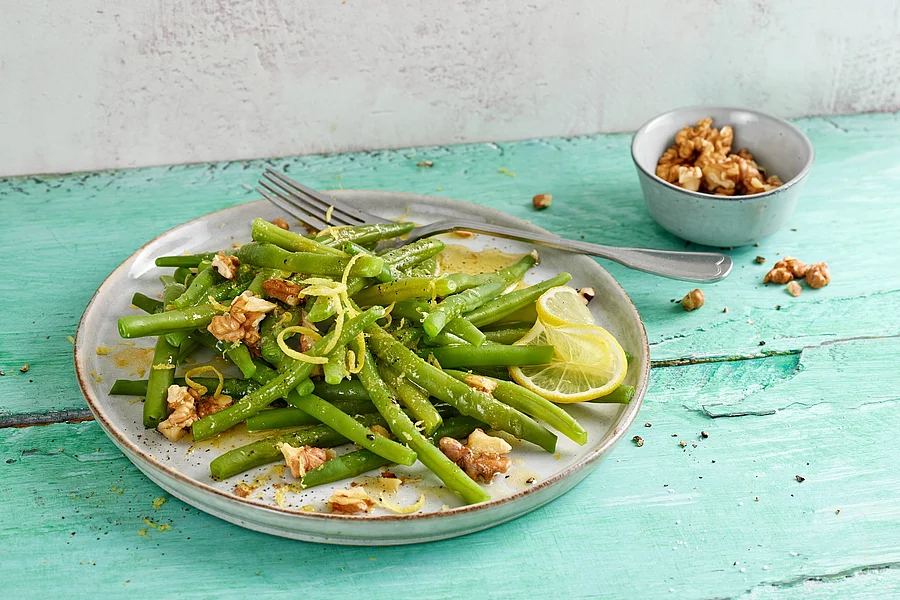 Bohnensalat mit Nüssen auf türkisem Tischtuch