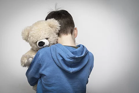 Trauriges Kind mit Teddy