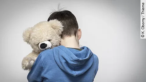Trauriges Kind mit Teddy