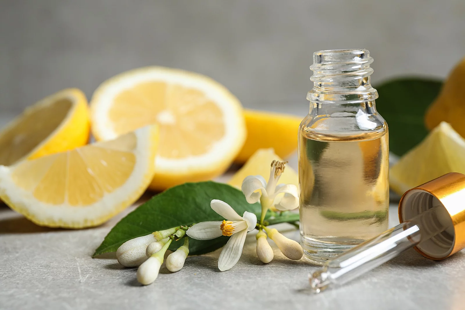 Citrus essential oil, flower and lemons on light table Citrus essential oil, flower and lemons on light table