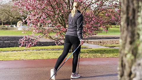 Nordic Walking Junge Frau beim Nordic Walking im Park