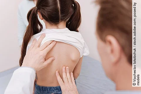 Arzt untersucht Mädchen an der Wirbelsäule