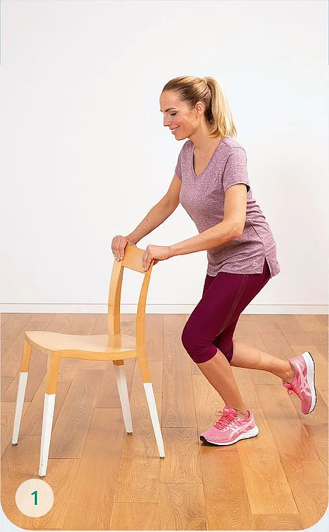 Frau macht Gymnatsik mit Stuhl.