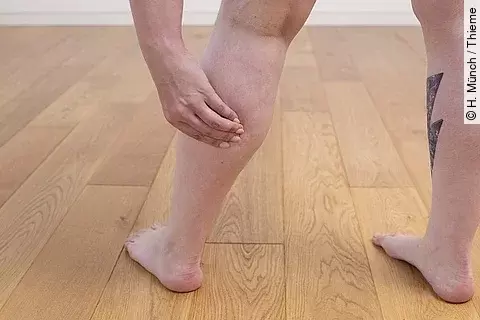 Frau, die sich ihren Unterschenkel hält