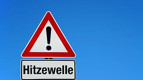 Symbolbild: Hitzewelle mit Achtungschild