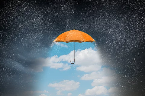 Symbolbild Depression: Oranger Regenschirm vor dunkelgrauem Regenhimmel