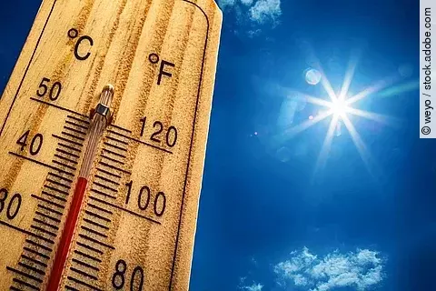 Ein Thermometer zeigt 40°C an. Im Hintergrund ist die Sonne im blauen Himmel zu sehen.