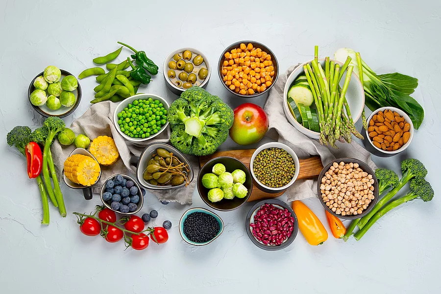 Healthy plant based food, best protein source on light grey background. pflanzliche proteinreiche Nahrungsmittel: Hülsenfrüchte, Mandeln, Bohnen, Erbsen, Beeren ...