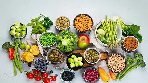 Healthy plant based food, best protein source on light grey background. pflanzliche proteinreiche Nahrungsmittel: Hülsenfrüchte, Mandeln, Bohnen, Erbsen, Beeren ...