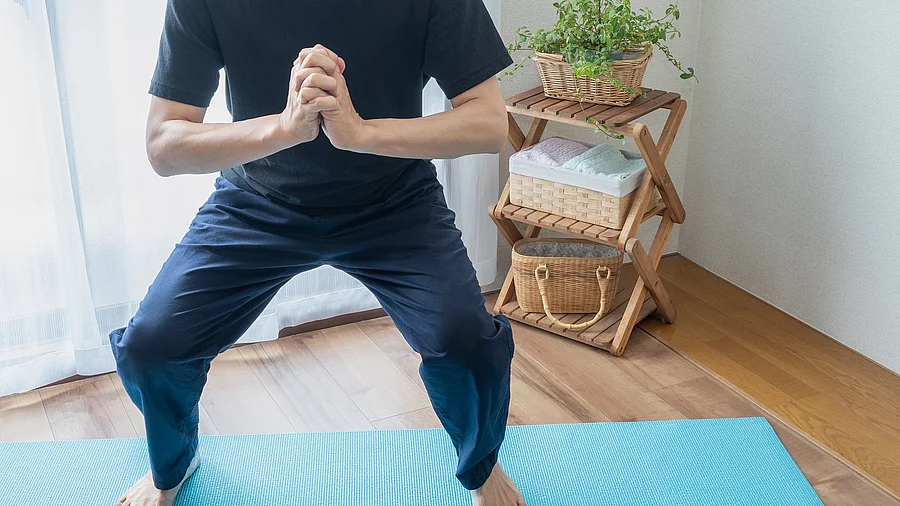 Mann macht Yoga auf einer blauen Yogamatte.