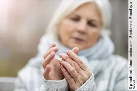 Ältere Frau reibt ihren Daumen