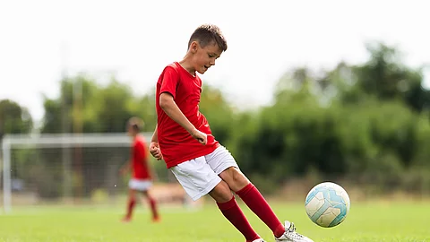 Junge spielt Fußball auf dem Fußballfeld