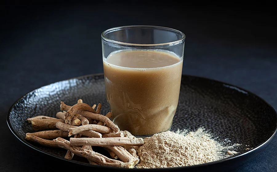 Getränk aus Ashwagandha-Wurzel mit Wurzeln und Churna (Pflanzenmehl).