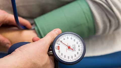 Arzt misst den Blutdruck eines Patienten. 